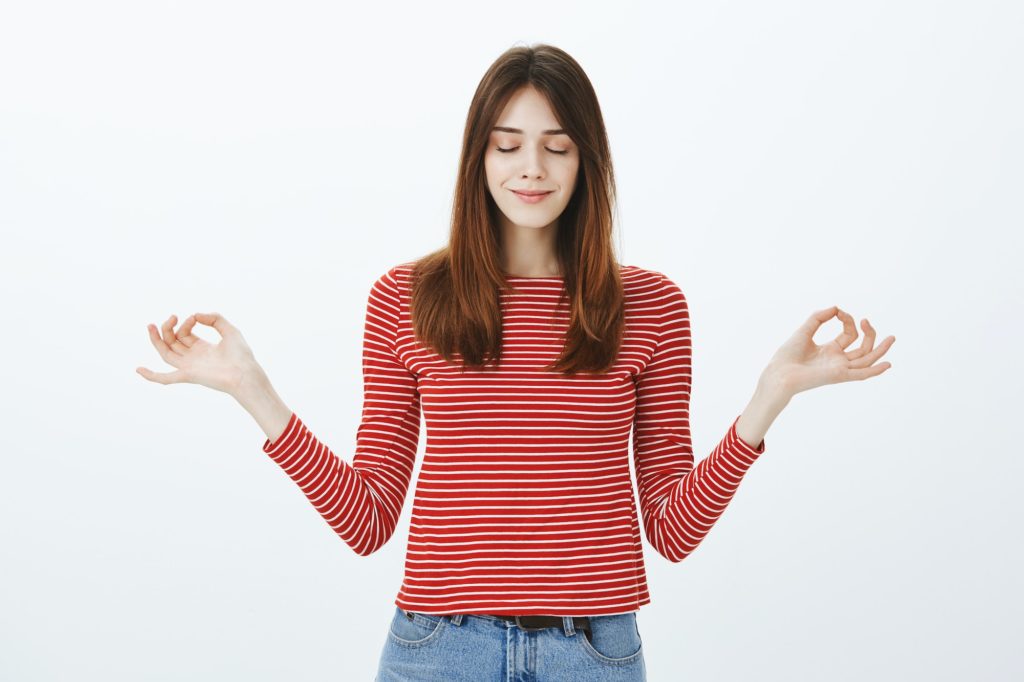 Girl gathering calmness before important exam. Pretty young female student in striped blouse